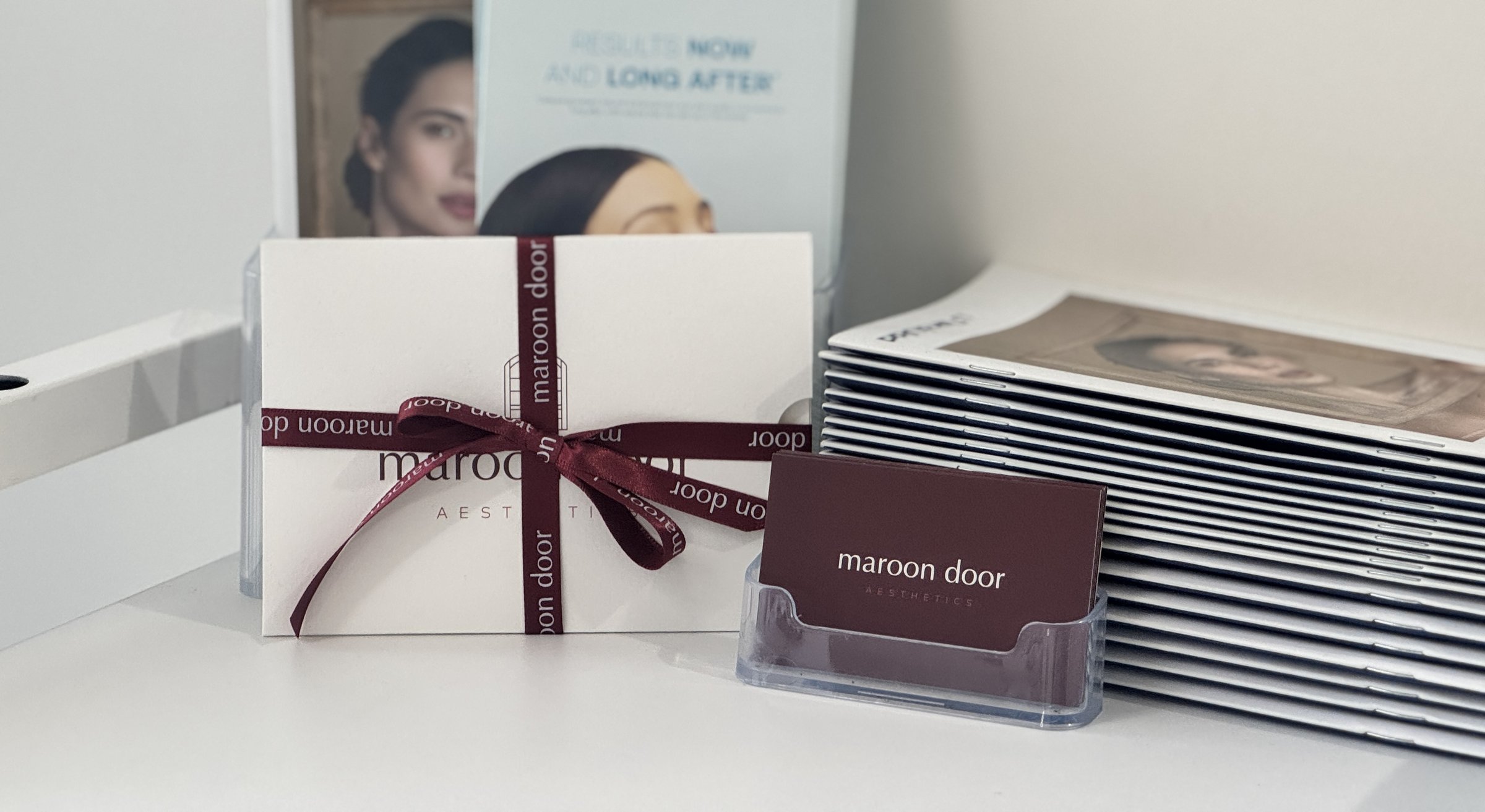 Maroon Door Aesthetics gift voucher, hand-finished in cream and maroon ribbon — available in clinic